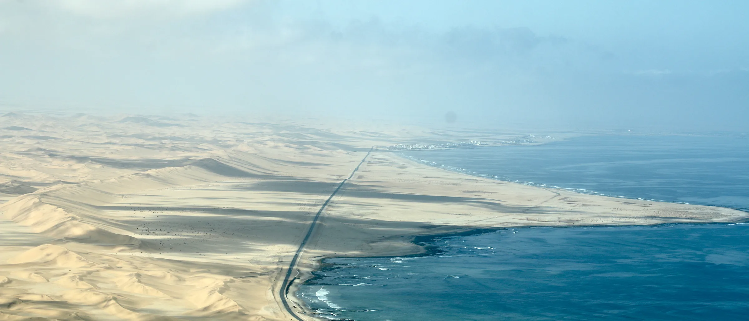 Aerial view of the B2 coastal road between Swakopmund and Walvis Bay, with Namib dunes on one side and the Atlantic on the other