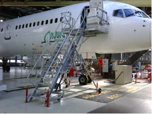 Access stairs set against the forward door of an airliner in a hangar