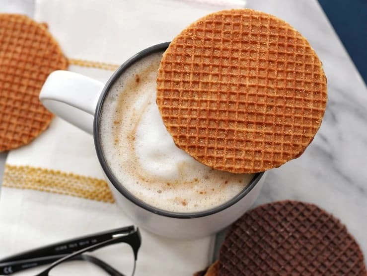 A Daelmans stroopwafel resting on a cup of coffee